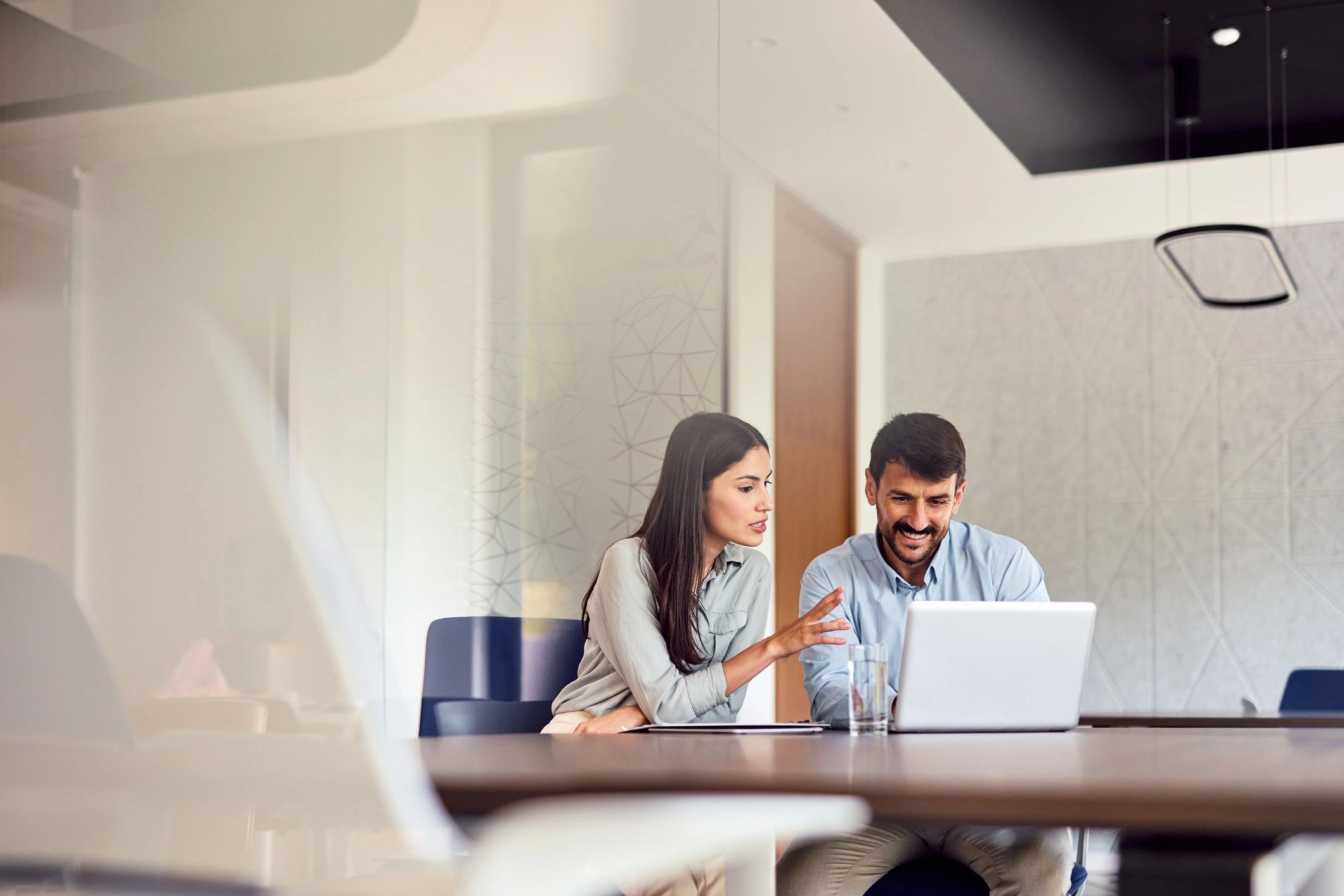 Two business professionals collaborating on a laptop