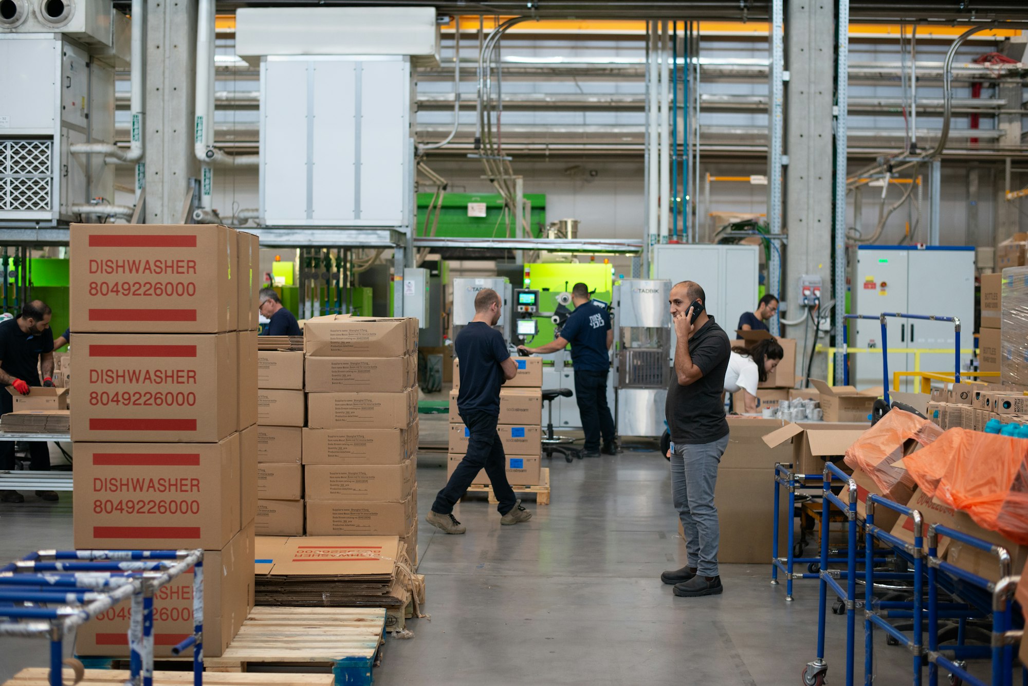 A man standing beside stacked cardboard boxes