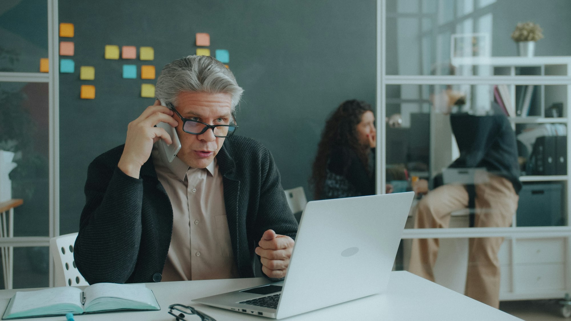 Managing director on the phone at his desk with a laptop