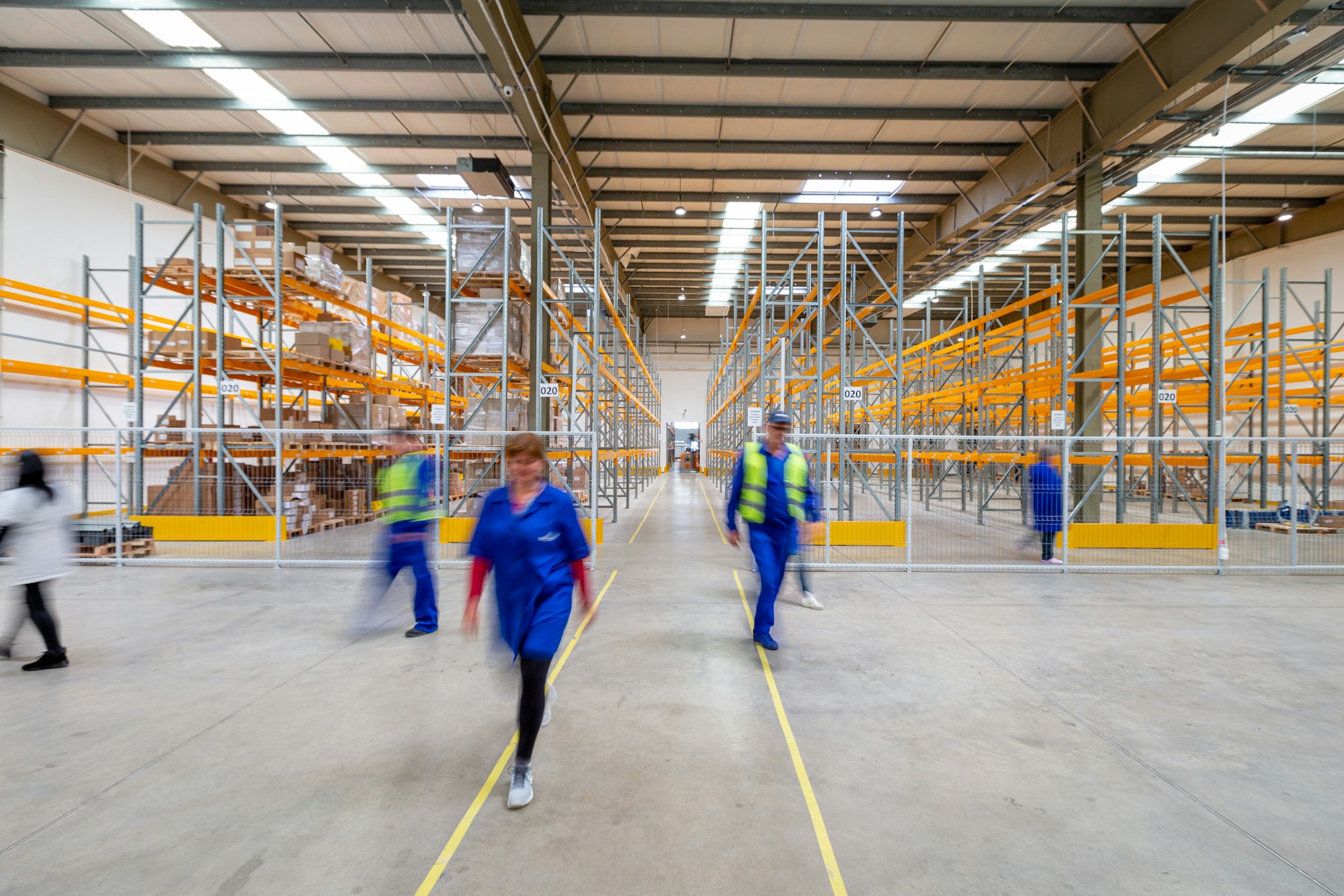 Warehouse team walking between shelves of stock